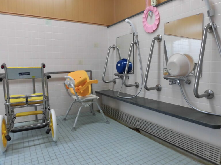 介護施設の浴室。リフト設備と安全手すりが完備された入浴環境。
